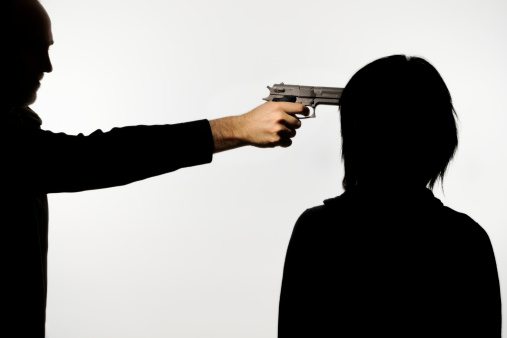 Silhouettes of man putting gun to woman's head